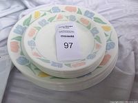 Top view of stacked Corelle plates with pastel floral pattern showing both smaller bread & butter plates and larger dinner plates.