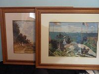 Two framed prints side by side against a blue wall, showing overall good condition and style of frames.