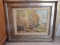 Full view of the framed fall scene painting with triple frame in fall tone and silver background with black speckles.
