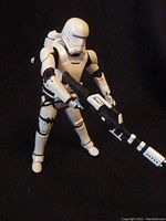 Full view of the white and black die-cast Flametrooper figure holding its weapon, standing upright against a dark background.
