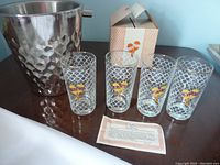 Photo of four vintage glasses with Maraca pattern and stainless steel hammered ice bucket on table