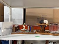 Shelf image showing pipe stand with glass jar, poker chip holder, cards, and Apple mouse box