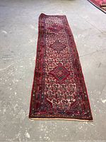 Full view of long Persian runner laid flat on floor showing overall design and condition