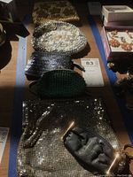 Five vintage clutches and change purses displayed side by side showing various beadwork and textures.