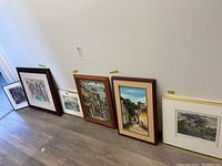 Six framed art prints leaning against a wall showing their relative sizes and frames.