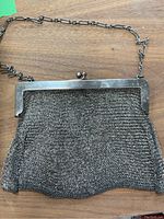 Full front view on wooden table, purse frame and mesh body visible