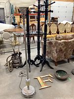 View of vintage floor lamp with onyx base, standing upright. Nearby metal letter F and artisan pot visible on floor.
