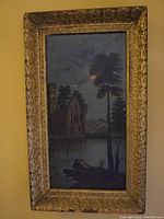 Full view of antique painting on canvas featuring moonlight over water, tall tree, gothic building, and gold gilded ornate frame with signs of wear.
