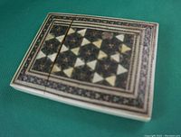 Top and angled views of the rectangular decorative box showing detailed geometric inlay patterns and slight imperfection in the design.