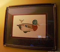 Framed numbered lithograph print of mallard drake decoy by Larry Crawford with brass corner frame.