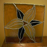 Full frontal photo of the square leaded glass panel with floral design on amber background.