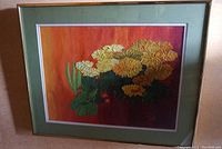 Full view of framed and matted floral oil painting leaning against wall
