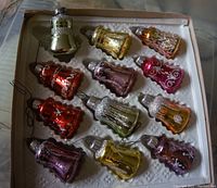 Box of 12 bell shaped mercury glass Christmas decorations in various colors with glitter detailing.