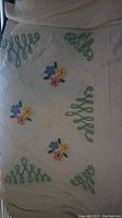 Full view of vintage chenille bedspread showing floral and green looped corner accents