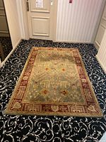 View of the Tree of Life area rug on patterned carpeted floor, showing overall design and size.