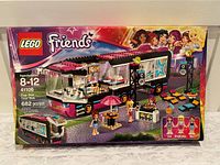 Front box image showing the LEGO Friends Pop Star Tour Bus set with the bus, stage, and mini-figures.