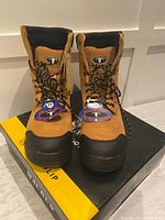 Front view of the pair of Taurus safety work boots size 11 with tags attached on top of the box