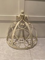 Front/side view showing heart-shaped scrollwork, finial top, and hooks inside