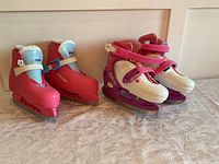 Red and purple girls ice skates arranged side by side, showing broad view of color and design.