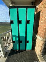 Front view of a bank of six half-size lockers with teal green doors and black framing.