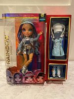 Skyler Bradshaw doll in box showing denim outfit with blue hair, extra outfits in side boxes