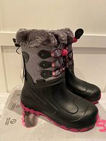 Pair of new girls winter boots size 3 with black rubber lower, gray fabric upper with red laces, and faux fur lining at the top.