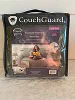 Packaging front of Couch Guard loveseat cover with brand and product name visible
