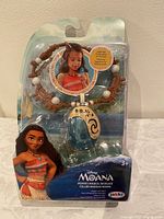 Front view of the Disney Moana Magical Necklace in original packaging, showing necklace design and character art.