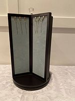 Front view showing two panels with hooks on fabric backing for jewelry hanging.