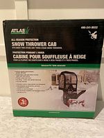 Box with product branding, features, and specifications of the Atlas Snow Thrower Cab, all-season protection for snow throwers.