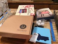 Watercolor painting kit, Chinese brush painting kit, and John Singer Sargent art book with unopened Underwood Letterpress kit in front, and blue car-themed notebook.