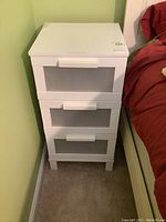 Front view of the white 3-drawer MDF cabinet showing translucent textured drawer fronts and white horizontal handles.