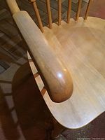 Close-up of captain chair armrest showing scratches and wear on wood finish