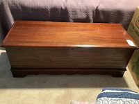 Closed view of vintage Lane cedar chest showing simple paneled wood design and keyhole on front.