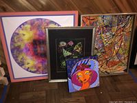 Four modern and contemporary artworks on floor showing diverse styles and colors.