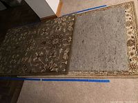 Overhead photo showing two area rugs side by side, brown floral and cream floral ornate patterns, with rug pads underneath