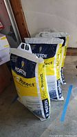 Three unopened bags of Morton Clean and Protect water softener pellets arranged in a row on concrete floor.