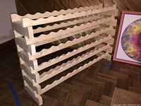 Unfinished wood wine rack showing overall side and front views with wave-shaped bottle holders on five horizontal shelves.