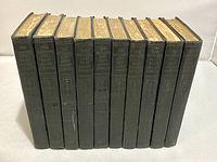 Front view of all 10 volumes showing green cloth hardcovers and embossed spine titles with gilt top edges.