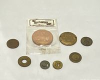 Nine tokens and medallions laid out on a flat surface showing an assortment of round tokens with inscriptions including 'Old San Francisco Mint' and others.