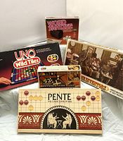 Photo showing all five vintage board and dice games together with their boxes and main pieces.