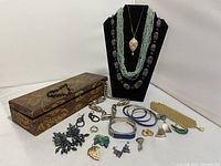 Full lot view showing jewelry pieces, necklaces on display, and decorative wood box.
