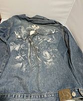Back of the denim jacket showing detailed graphic print of Jack Skellington and ghostly figures.