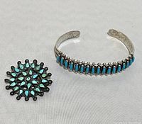 Top view of the turquoise pin and sterling silver cuff bracelet showing overall condition and design.