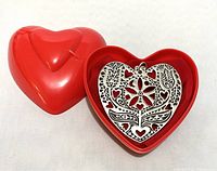 Photo showing the sterling silver heart pendant inside the red plastic heart-shaped box.