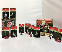 Front view of the lot showing miniature Coca-Cola character ornaments, vehicles, and two vintage Coca-Cola tins along with Santa ornament in box.