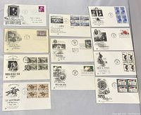 Top view of 11 white envelopes arranged flat, showing fronts with stamps, cancellation marks, and various commemorative cachets from 1947 to 1967.