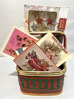 Woven basket with vintage holiday postcards partially inside and a boxed set of star-shaped clip string lights