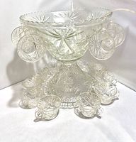 Photo of assembled vintage glass punch bowl set with cups hanging and base plate underneath