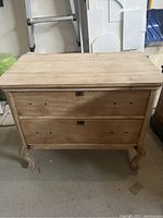 Front view of the antique dresser showing two drawers without handles and curved cabriole legs